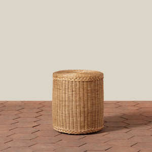 Woven cylindrical stool on a wooden floor with a neutral background - Number 2