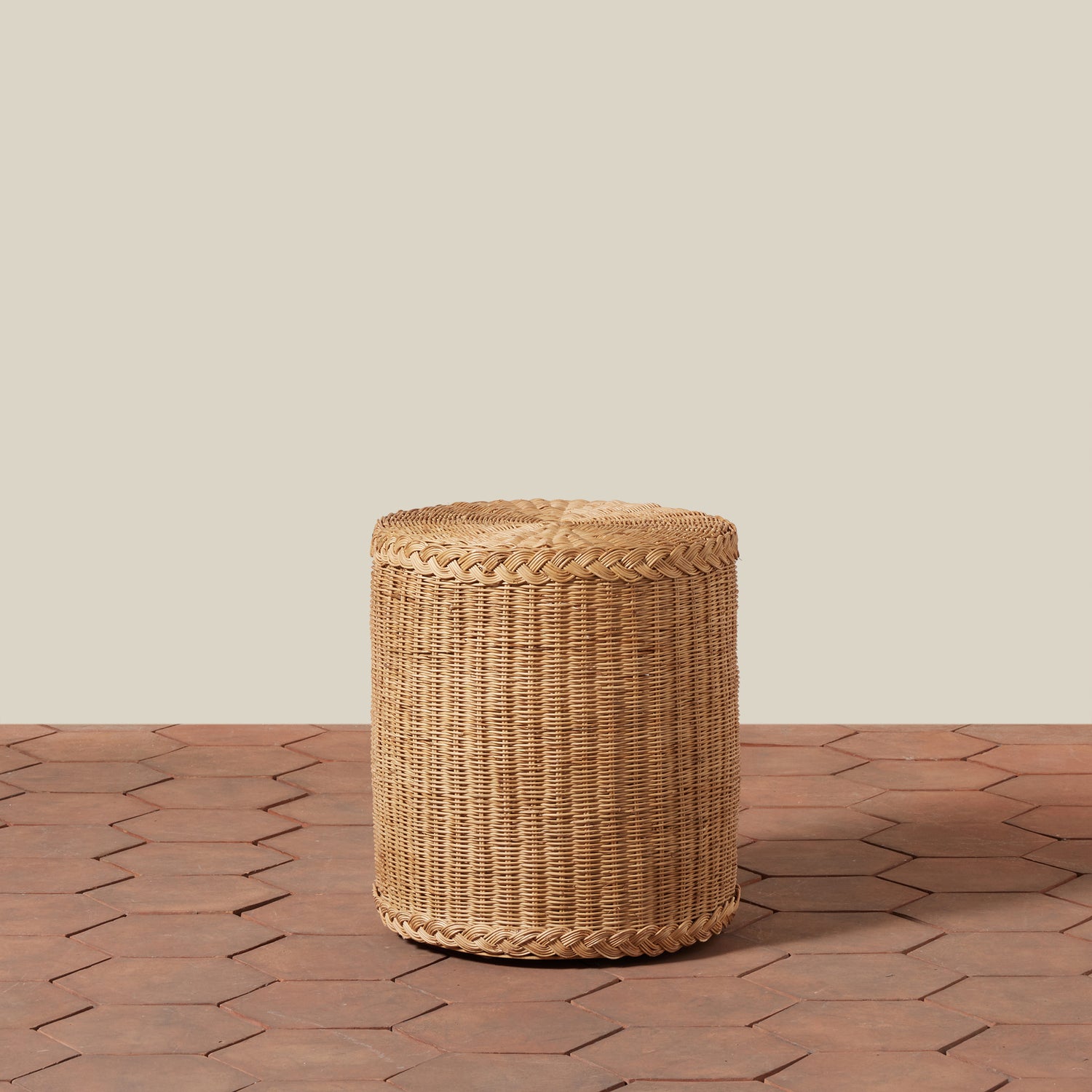 Woven cylindrical stool on a wooden floor with a neutral background- Number 1