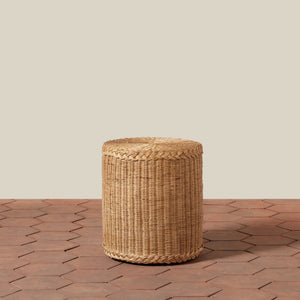 Woven cylindrical stool on a wooden floor with a neutral background - Number 1