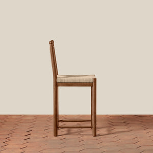 Wooden bar stool with woven seat on a wooden floor and beige wall background - Number 3
