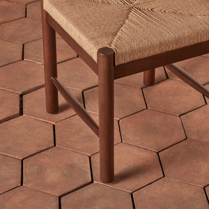 Chair with woven seat on a hexagonal patterned patio floor - Number 8