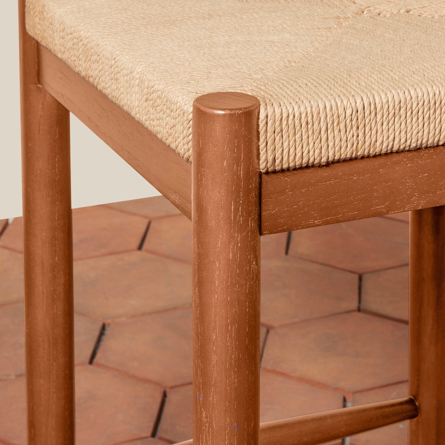 Wooden chair with a textured beige cushion on a tiled floor.- Number 12