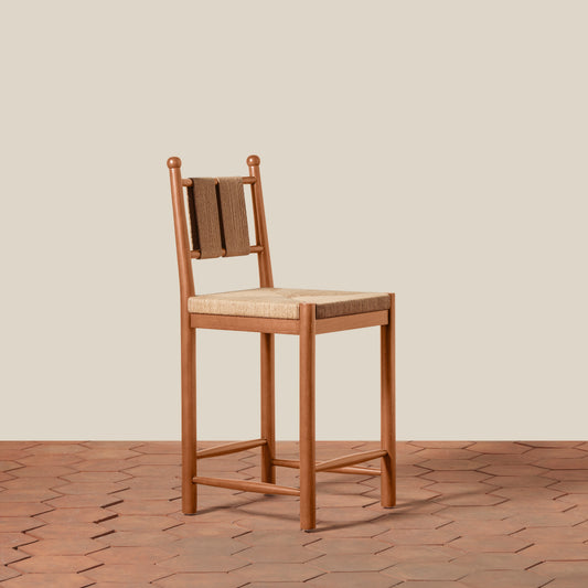 Wooden chair with woven backrest on a wooden floor and beige wall background