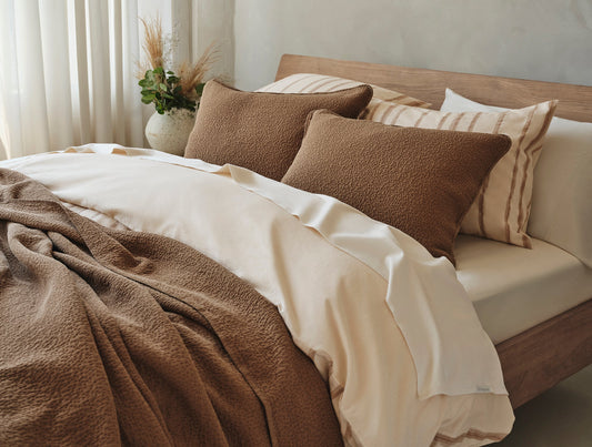 Bed with brown and beige bedding and pillows in a cozy bedroom setting. - Image 2