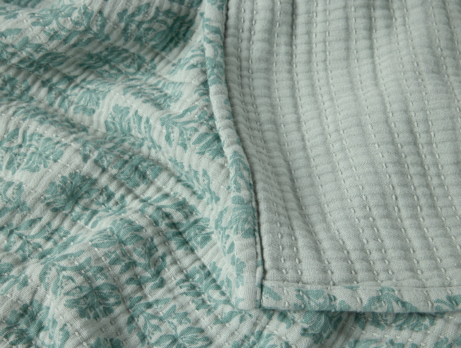 Textured fabric with a subtle pattern, possibly a quilt or throw blanket.- Number 6