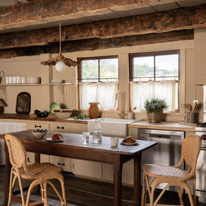 Cozy kitchen with wooden table and chairs, rustic beams, and natural light. - Number 2