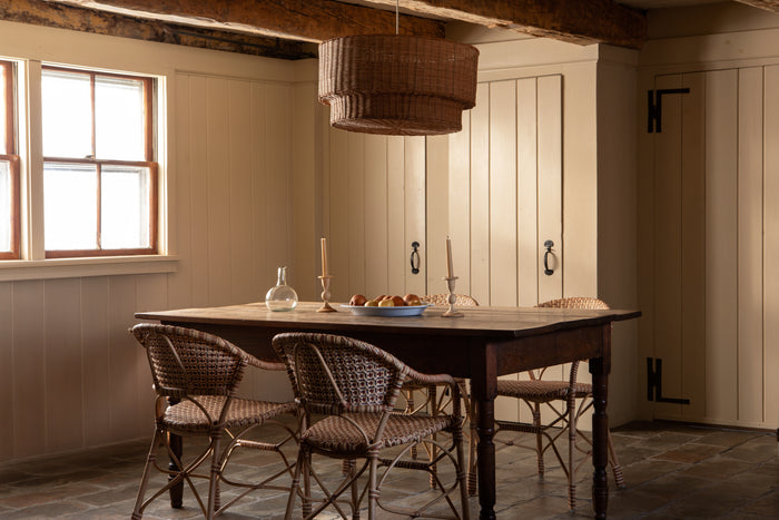 Dining room with wooden table and chairs, candlesticks, and a lamp.
