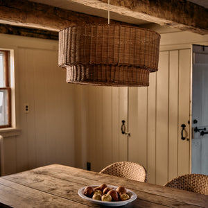 Rustic dining room with wooden table, wicker chairs, and a woven pendant light. - Number 3