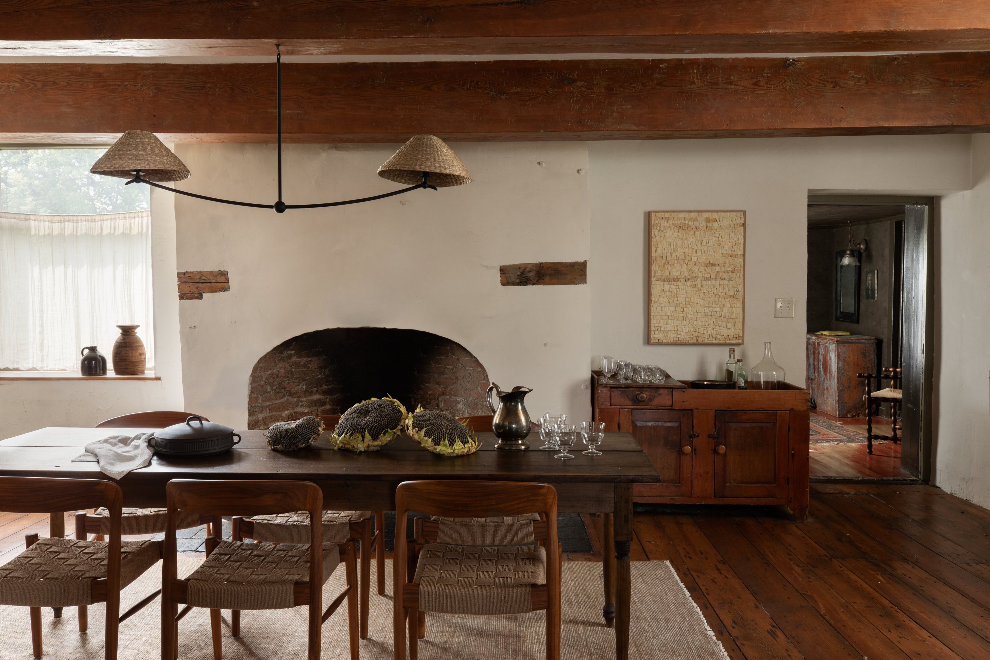 Dining room with wooden table, chairs, and a fireplace.