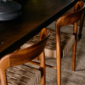 Wooden chairs with woven seats around a dark wooden table on a carpeted floor. - Number 3