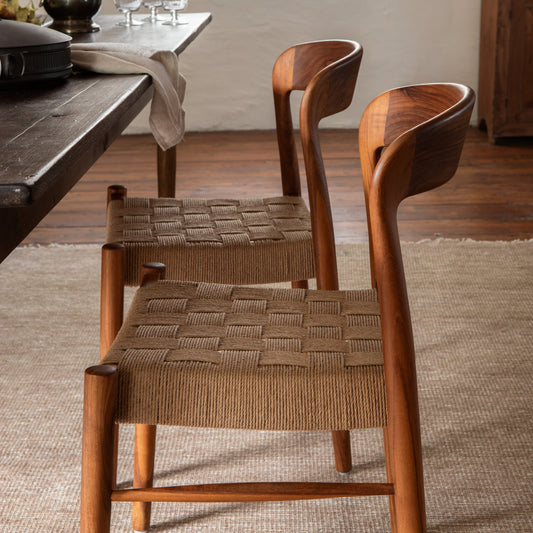 Wooden chairs with woven seats in a room with a table and carpet. - Image 2