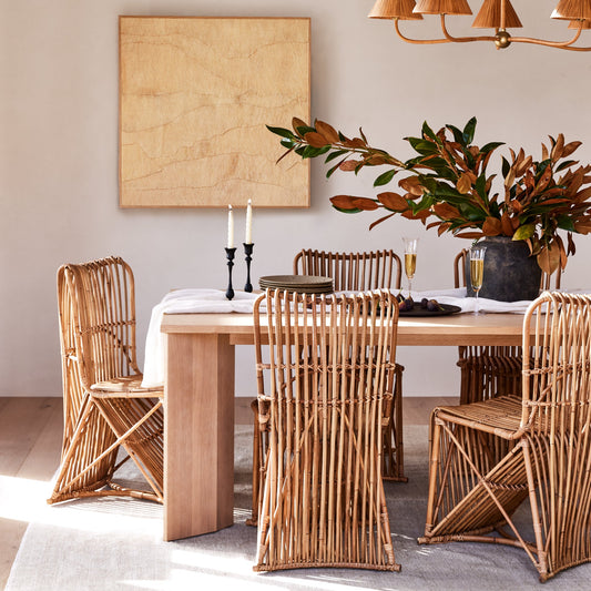 Dining room with wooden table and wicker chairs, featuring a chandelier and wall art. - Image 2