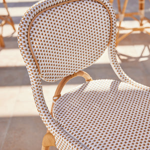 Wicker chair with checkered pattern on a sunny outdoor patio - Number 3