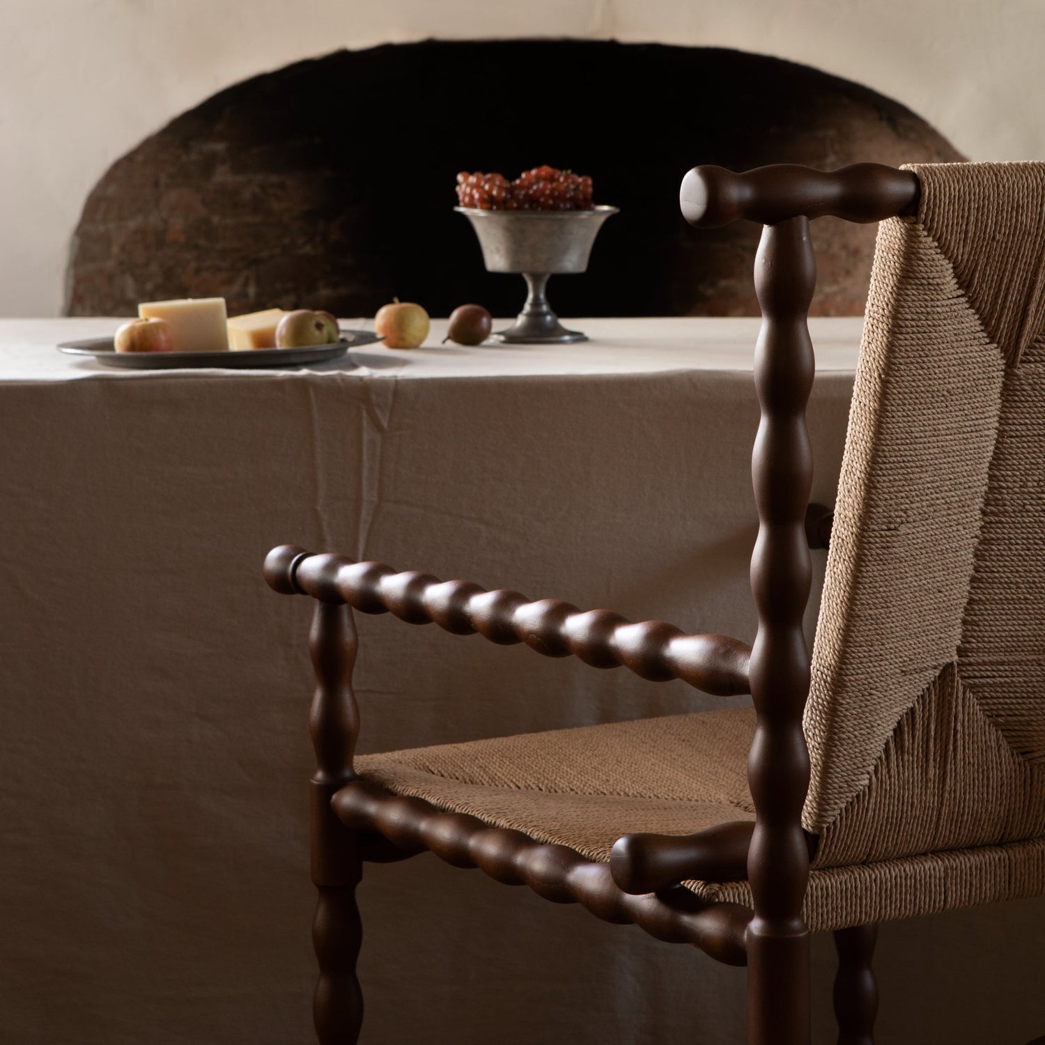 Dining room with a table set for a meal, featuring a chair and a fireplace in the background.- Number 3