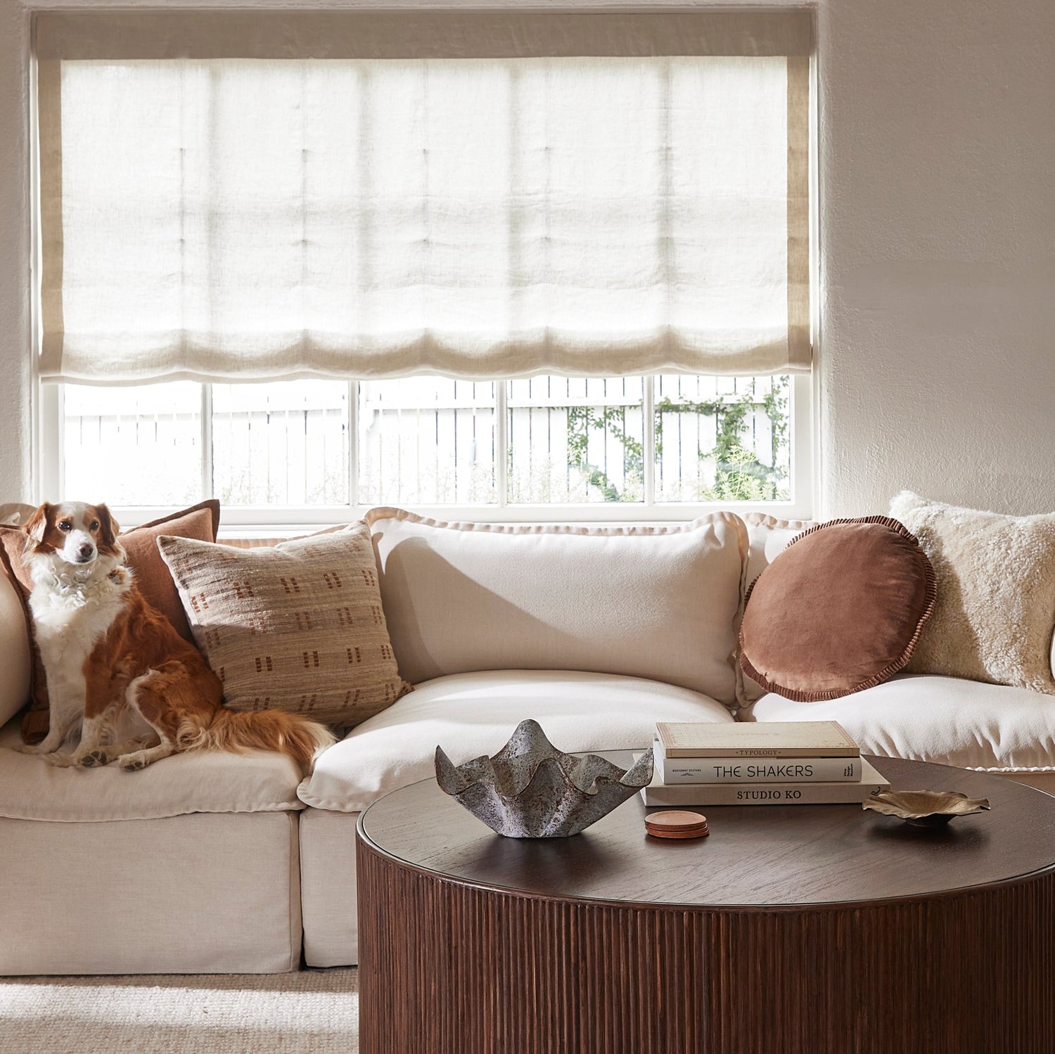 Living room with a beige sectional sofa, coffee table, and decorative items.- Number 2