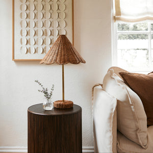 Lamp on a side table next to a sofa with decorative pillows, framed wall art in the background. - Number 2