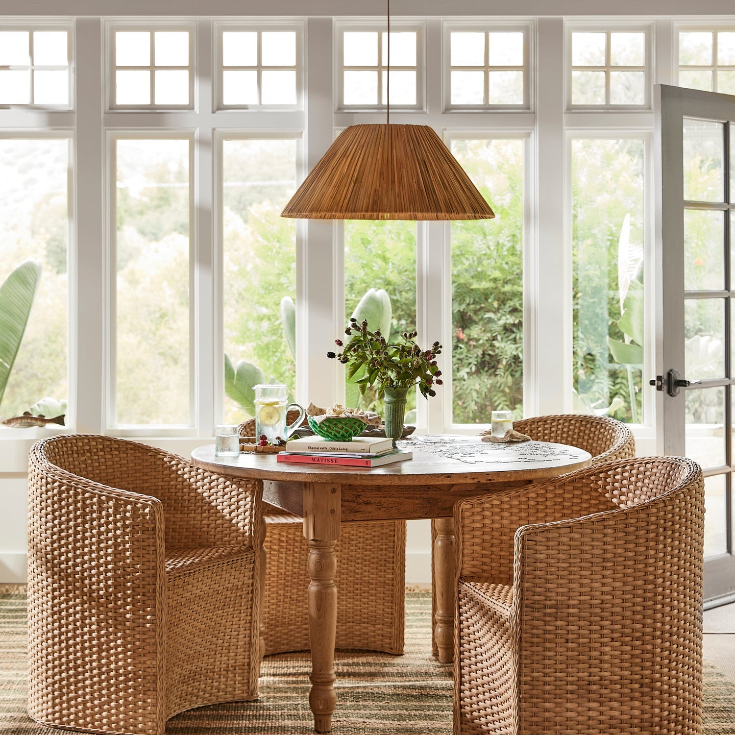 three large chairs around circular table with rattan pendant light above- Number 2
