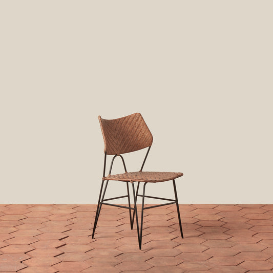 Wicker chair with metal legs on a wooden floor and beige wall