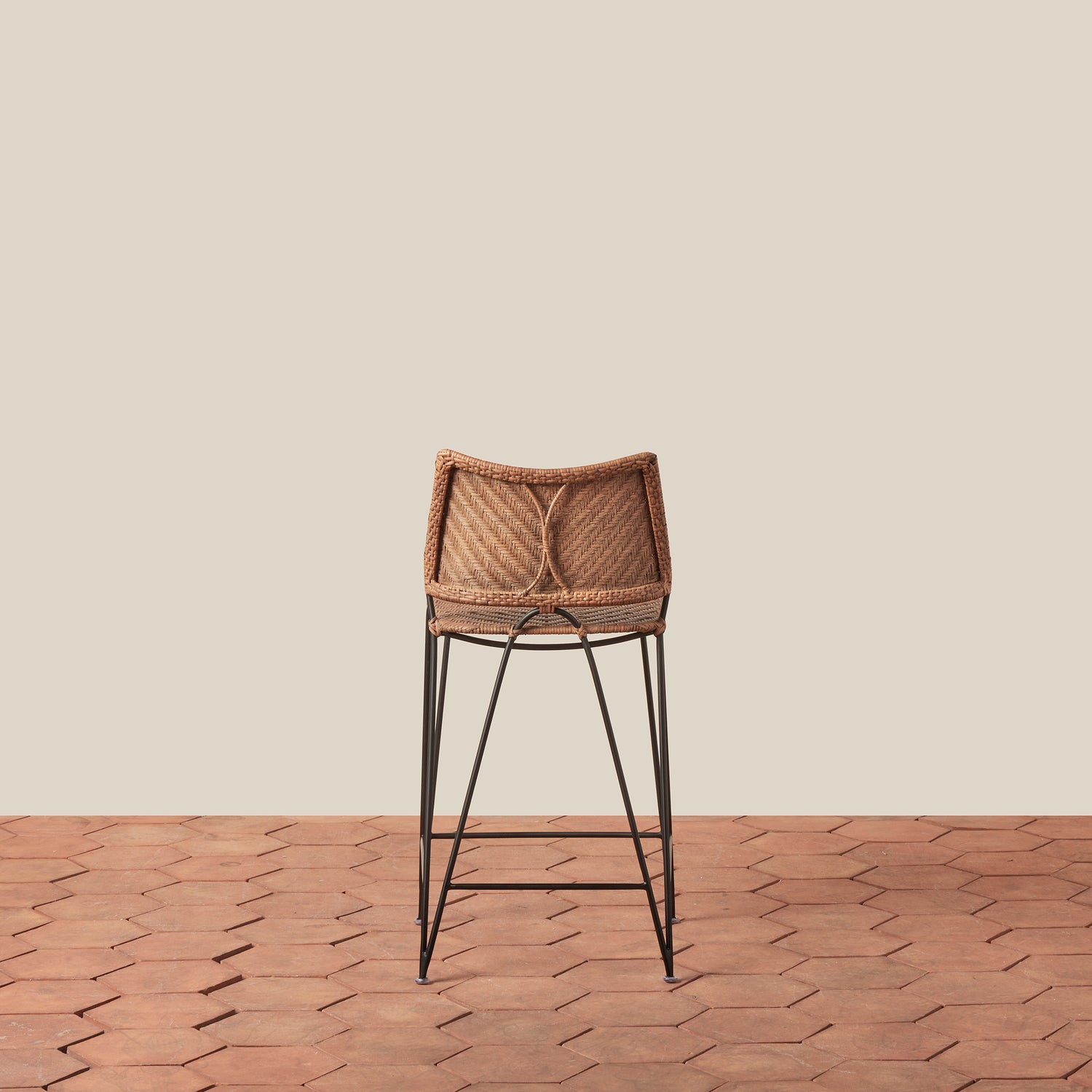 Bar stool with woven seat and metal legs on a wooden floor and beige wall background- Number 4