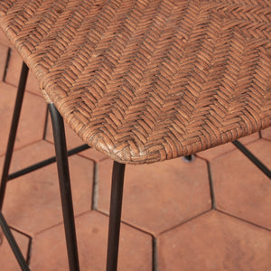 Close-up of a wicker chair seat on a brick pavement - Number 6