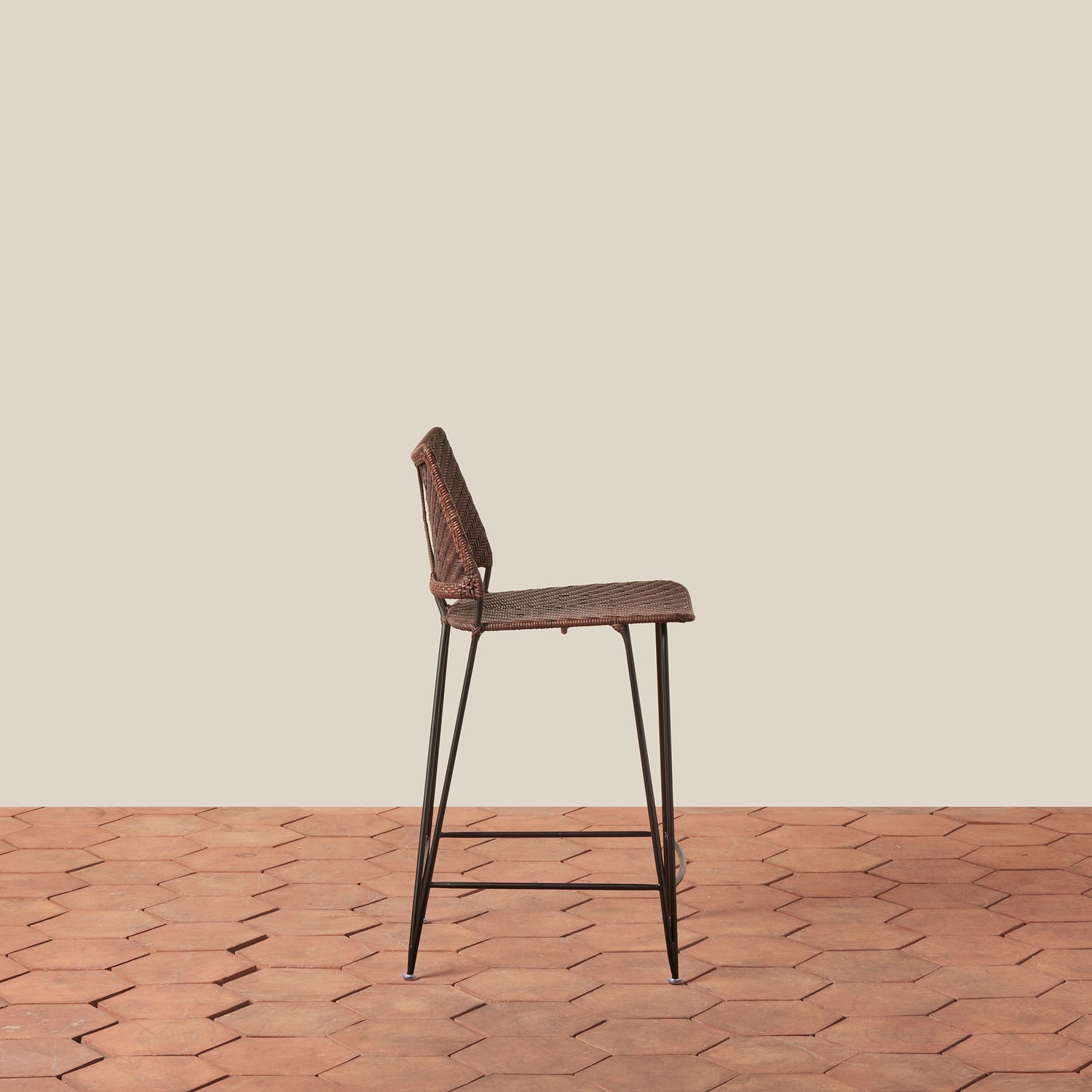 Bar stool with woven seat and metal legs on a wooden floor with beige wall background- Number 8
