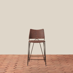 Brown woven bar stool on a wooden floor with a beige wall background - Number 9