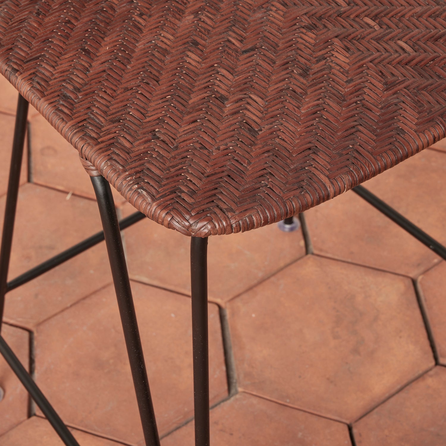Brown wicker chair on a hexagonal patterned patio floor- Number 12