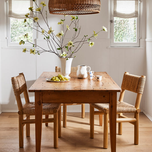 Dining room with wooden table and chairs, wicker pendant light, and decorative elements. - Image 2