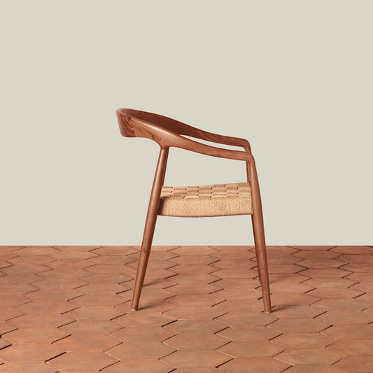 Wooden chair with woven seat on a wooden floor and beige wall background - Image 2