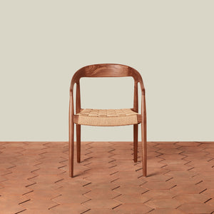 Wooden chair with woven seat on a wooden floor and beige wall background - Number 3