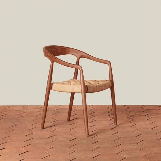 Wooden chair with a woven seat on a wooden floor.