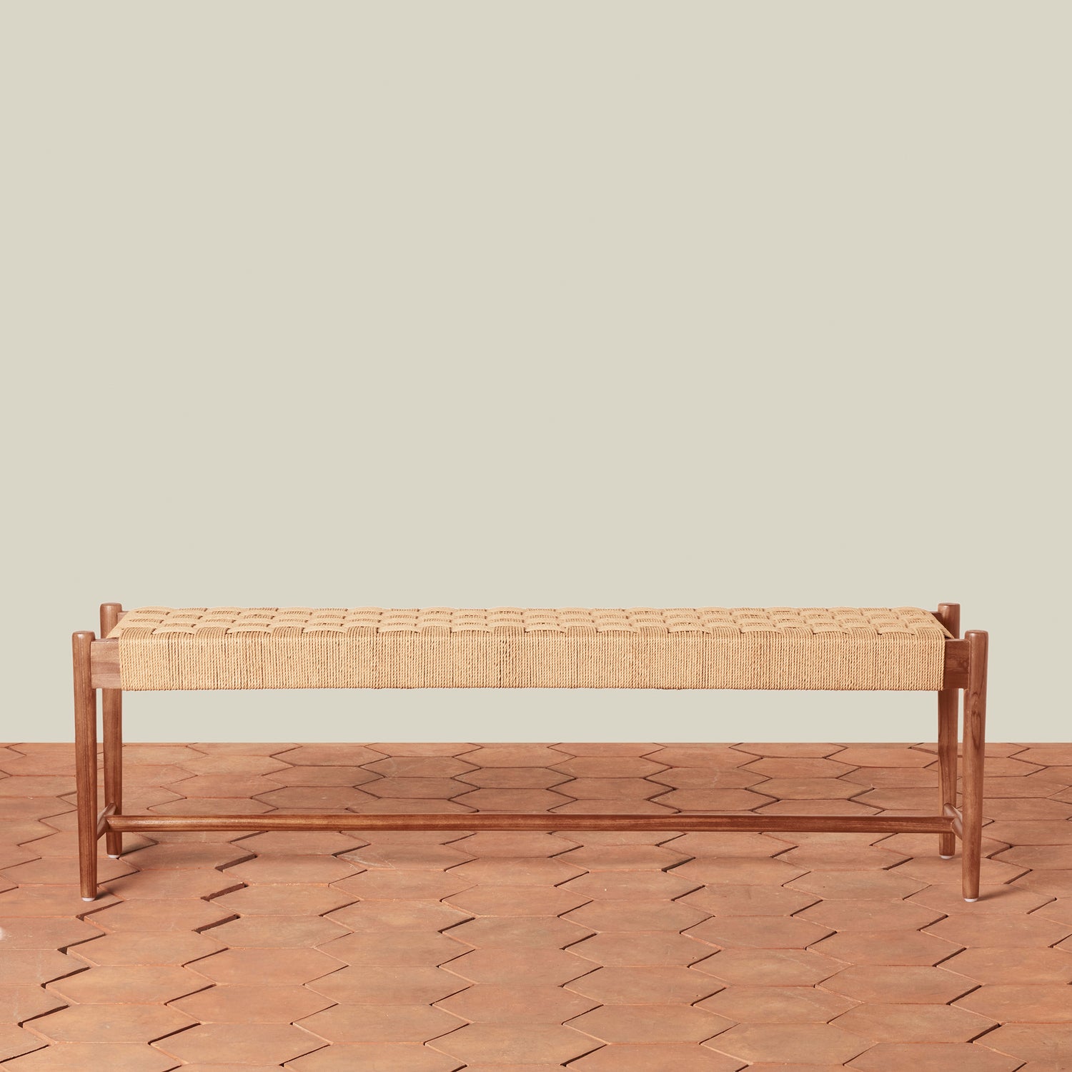 Wooden bench with woven seat on a wooden floor against a beige wall- Number 2
