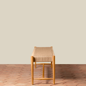 Wooden stool with woven seat on a wooden floor against a beige wall - Number 9