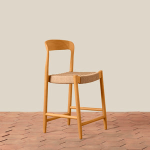 Wooden bar stool with woven seat on a wooden floor and beige wall background - Number 1