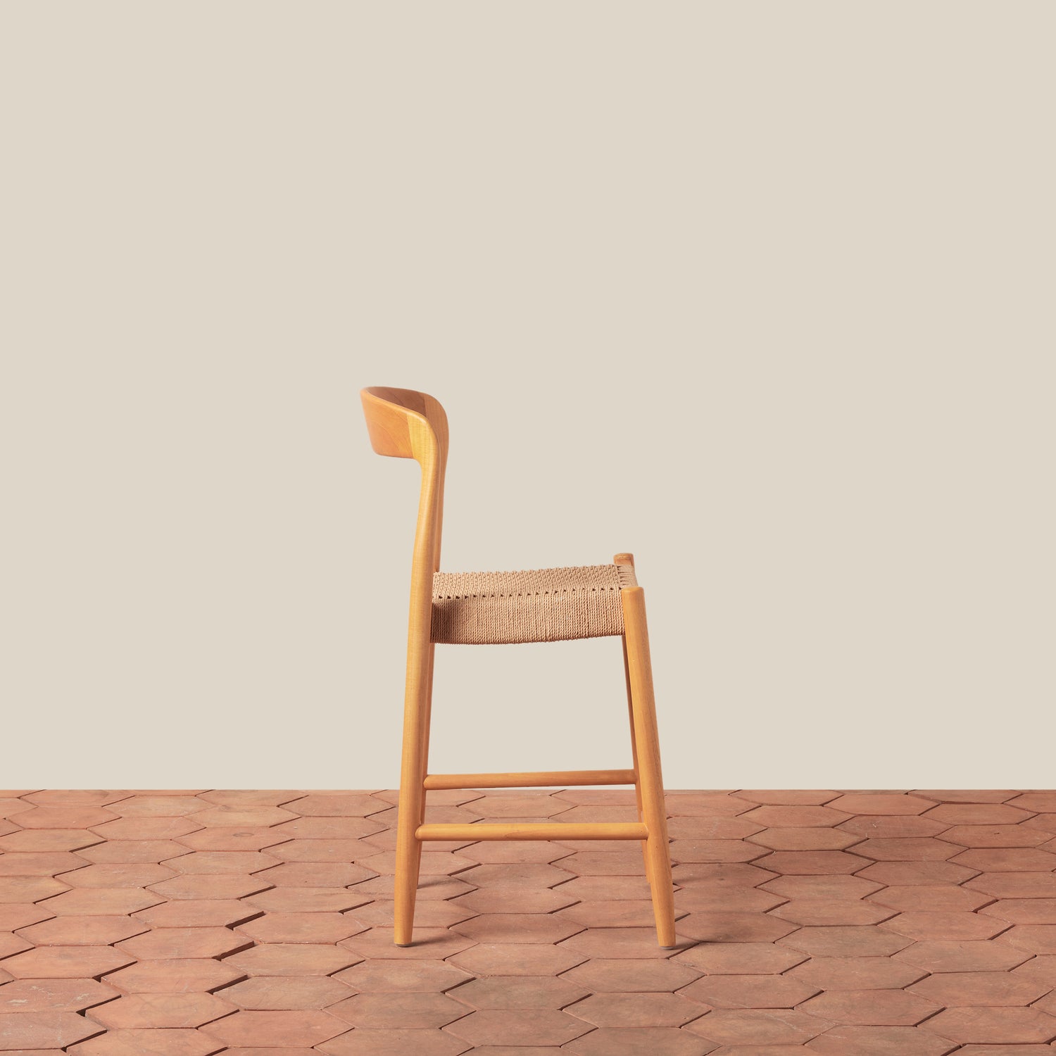 Wooden bar stool with woven seat on a wooden floor and beige wall background- Number 4