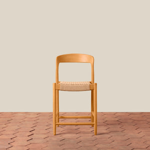 Wooden chair with woven seat on a wooden floor and beige wall background - Number 3
