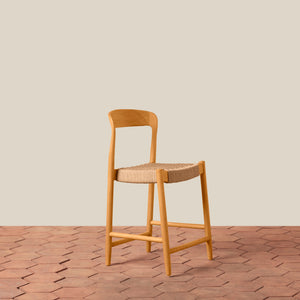 Wooden bar stool with woven seat on a wooden floor and beige wall background - Number 1