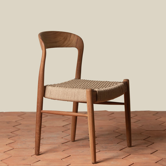 Wooden chair with woven seat on a wooden floor and beige wall background