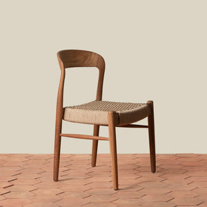 Wooden chair with woven seat on a wooden floor and beige wall background - Number 1