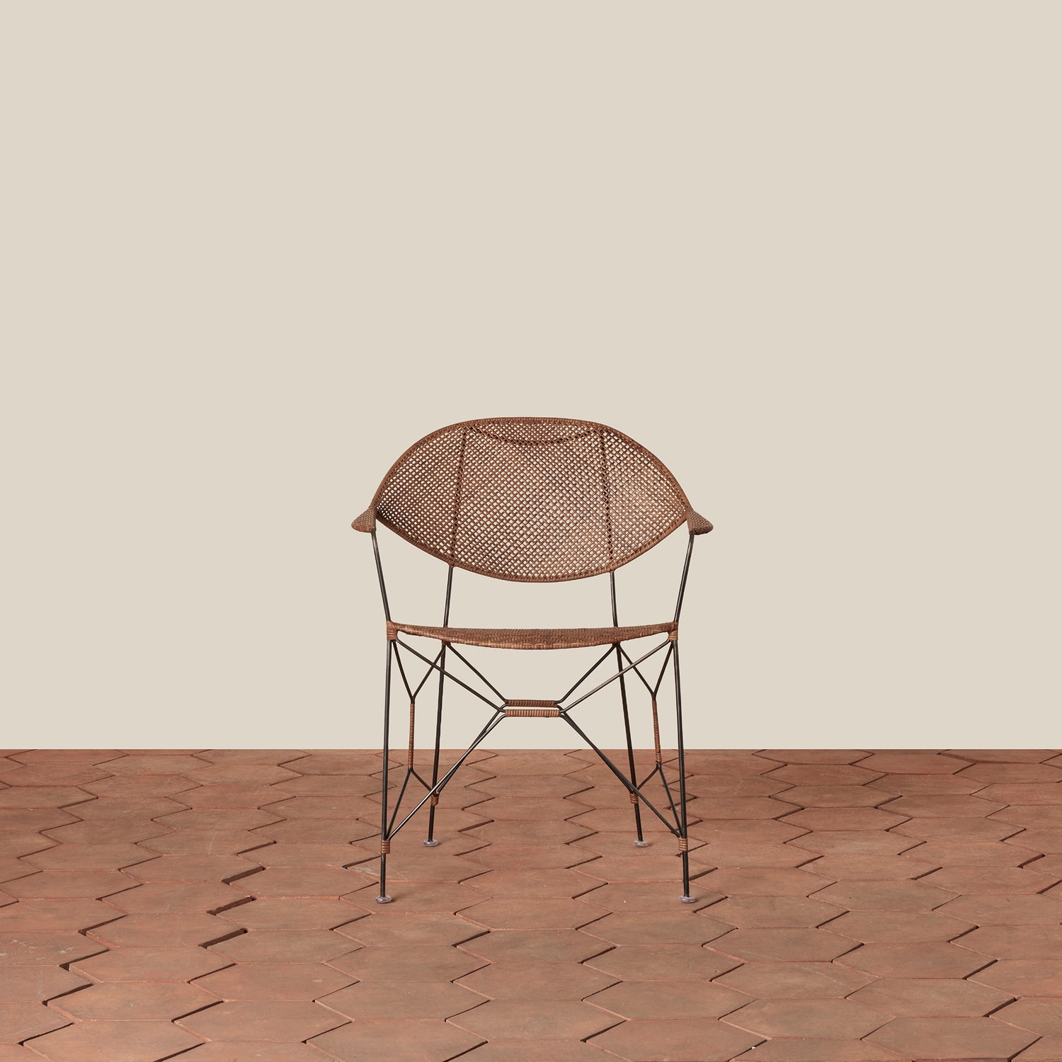brown rattan and iron chair with pointed legs on tile floor against white background- Number 3