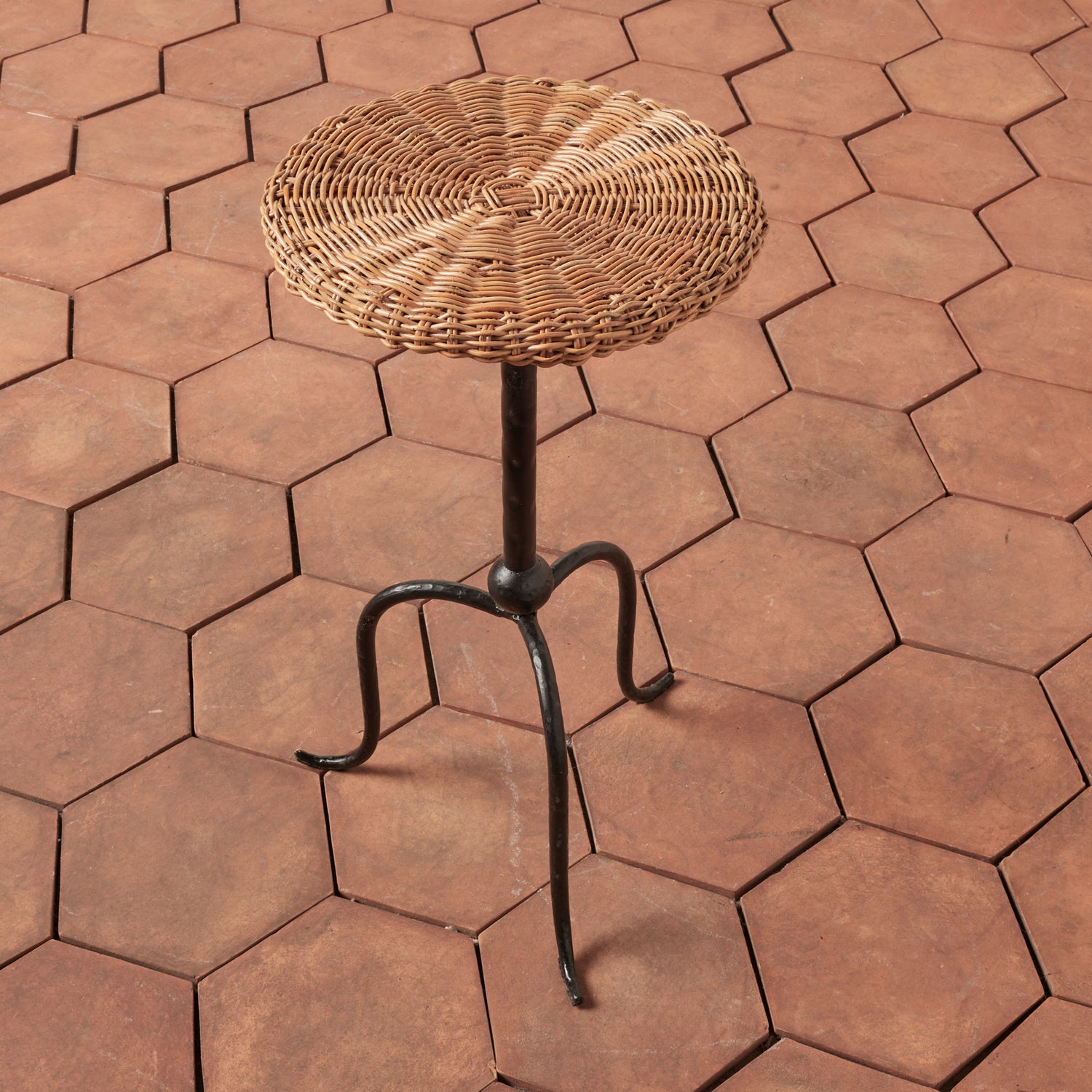 Wicker stool on a hexagonal brick-patterned patio- Number 2