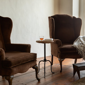 Two brown armchairs in a room with a small table and a blanket. - Number 3