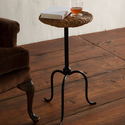 Small wicker side table with a glass of amber liquid and a book on a wooden floor. - Image 2