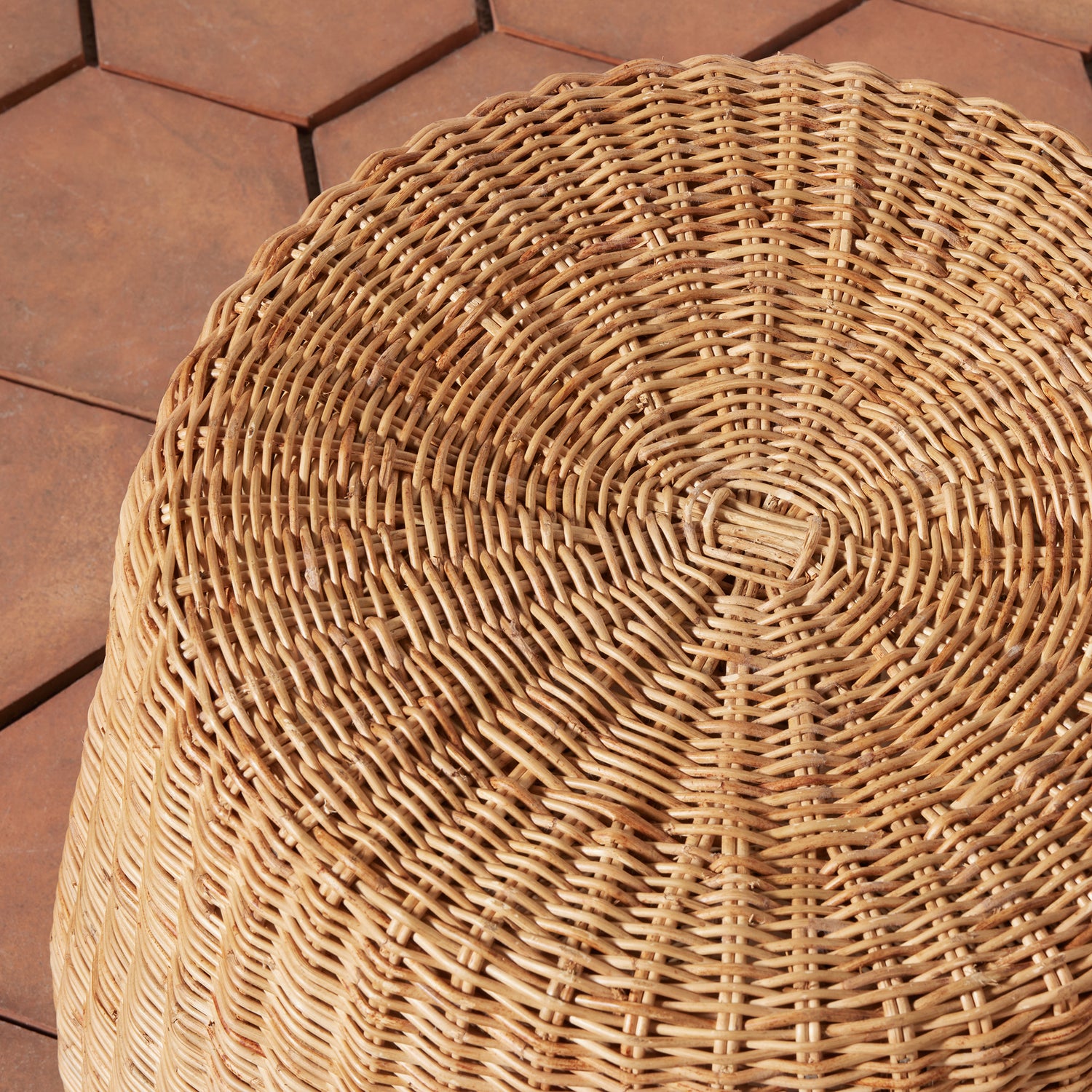 Close-up of a woven wicker stool on a wooden deck.- Number 4