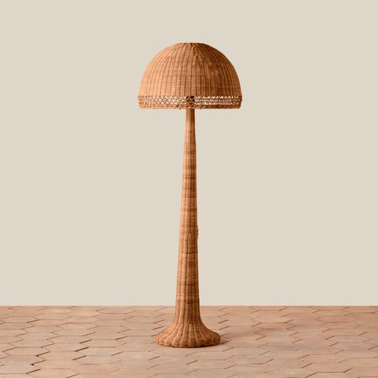 Woven floor lamp on a wooden floor with a neutral background