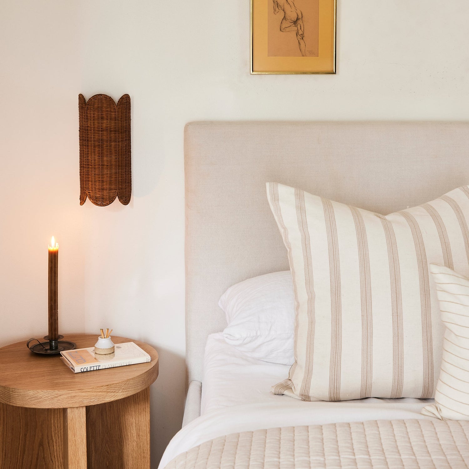 Bedroom with a bed, wooden side table, and wall art.- Number 2