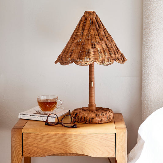 Wicker table lamp on a wooden side table with a cup and glasses against a neutral wall. - Image 2