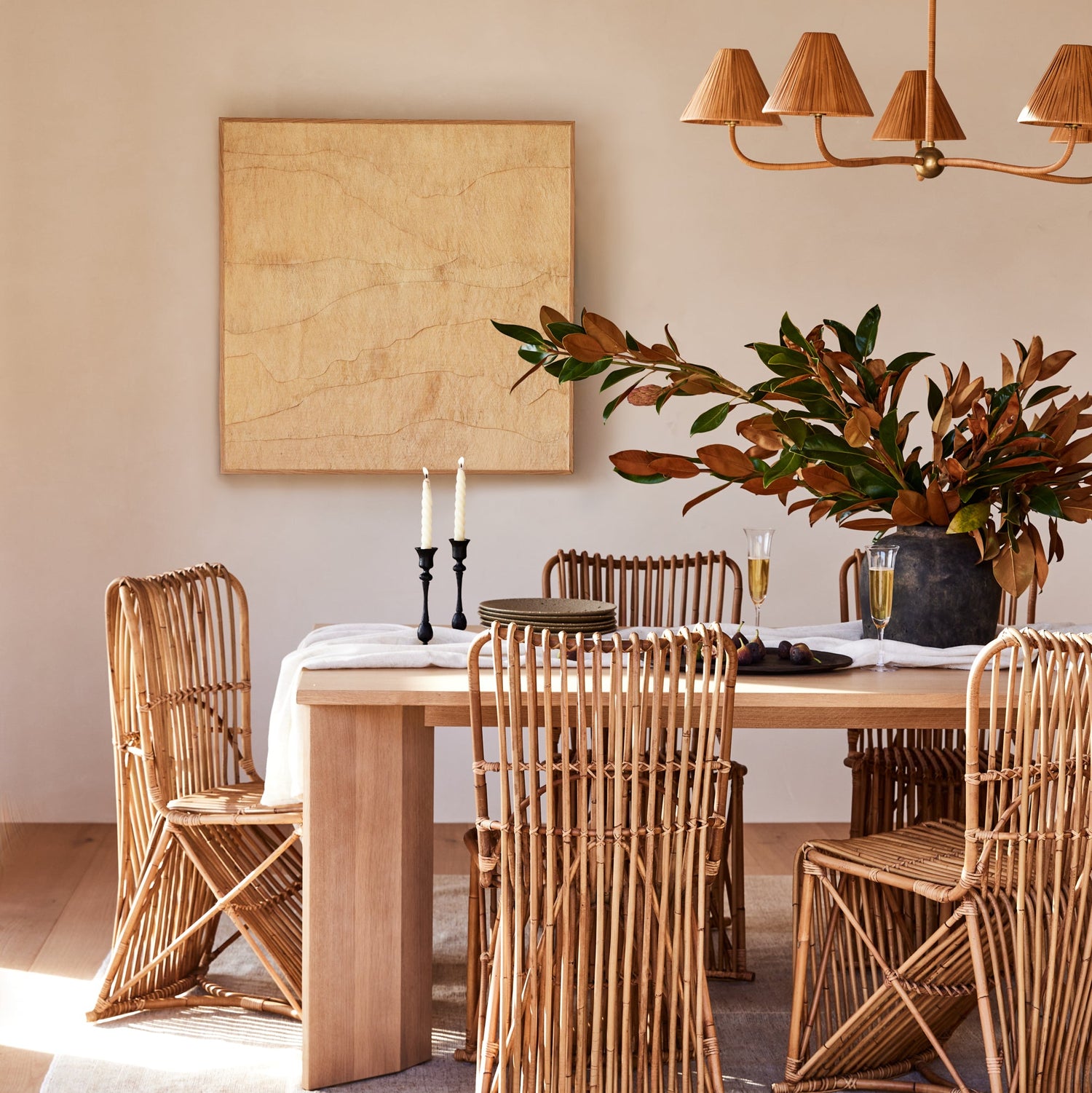 wooden table with brown chairs, chandelier, and beige painting hanging against white wall with flowers on top of table- Number 2
