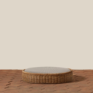 Round woven basket with a striped cushion on a wooden floor. - Number 15