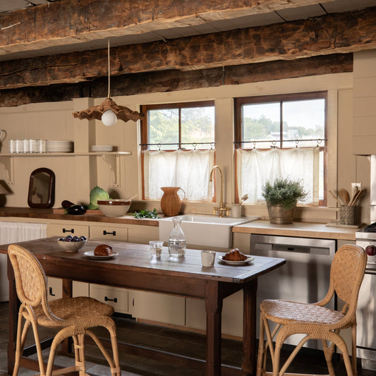 Kitchen with wooden table and chairs, rustic beams, and natural light. - Image 2